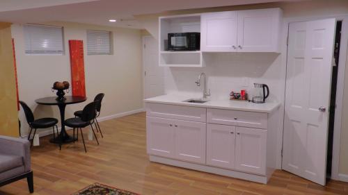 Una cocina con gabinetes blancos y una mesa con sillas. en Lincoln Howard House, en Washington