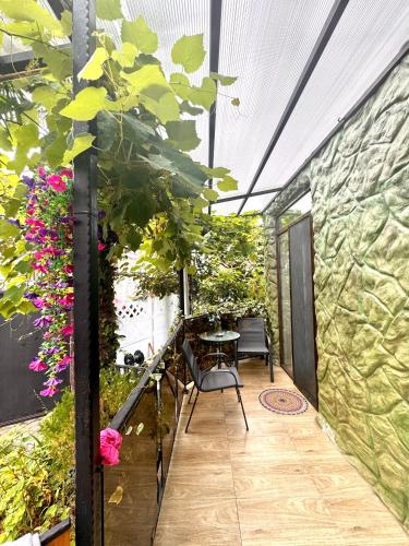 a patio with a table and chairs and flowers at PAPILLON in Chakvi