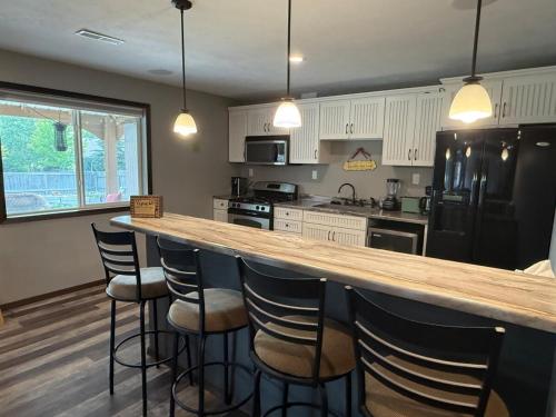 a kitchen with a bar with stools in it at Relaxing Retreat with Cozy Patio in Sioux Falls