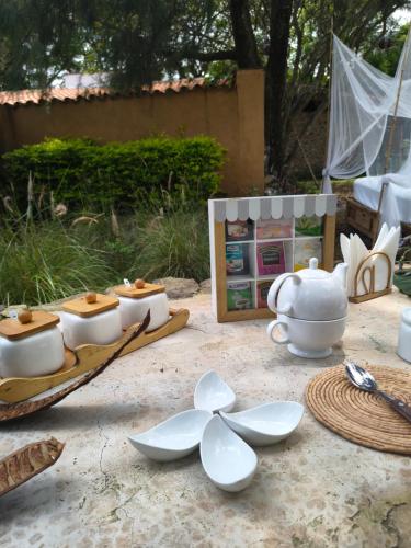a table with white bowls and dishes on it at Paraje Real Malinalco in San Martín