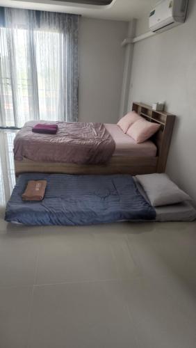 two beds sitting in a room with at หลังมอ อพาร์ตเมนต์สามสาว in Ban Hua Khwai