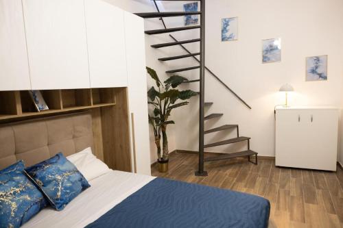 a bedroom with a bed with blue pillows and a staircase at My Home in Barletta