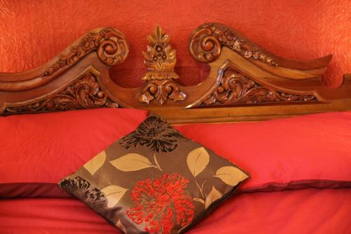 a bed with a wooden headboard with a crown on it at Angel Guesthouse in Tiverton