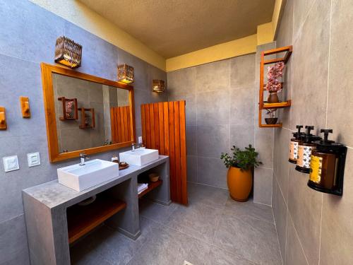 a bathroom with two sinks and a mirror at Terrasa Solar Hotel in Icaraí