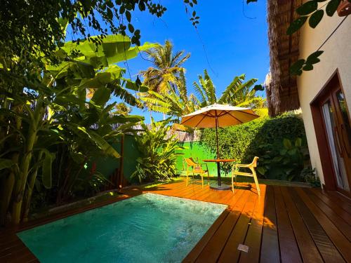 a small pool with an umbrella and a table and chairs at Terrasa Solar Hotel in Icaraí