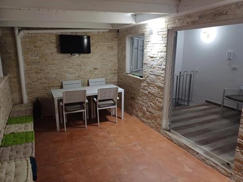 a dining room with a table and chairs and a television at My Home in Barletta