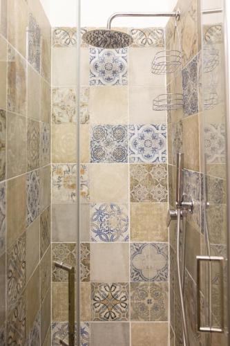 a bathroom with a shower with blue and white tiles at My Home in Barletta