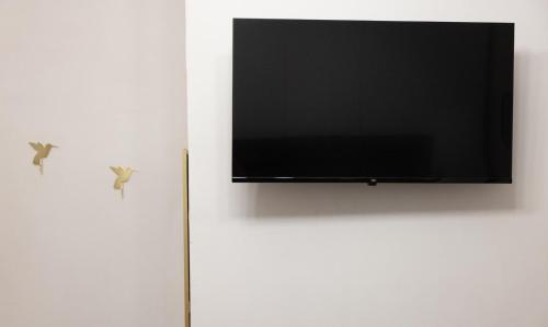 a flat screen tv hanging on a white wall at My Home in Barletta