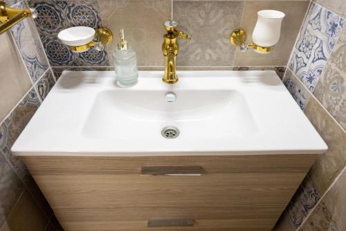 a bathroom with a white sink and gold fixtures at My Home in Barletta