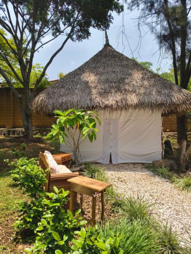 a white hut with a bench and a table at Paraje Real Malinalco in San Martín