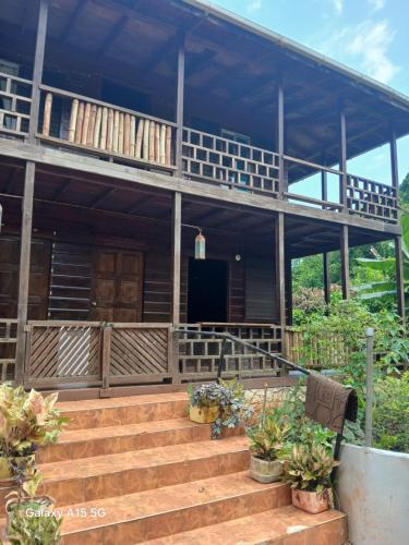 a house with stairs and a porch with plants at Natural living guest house in Negril