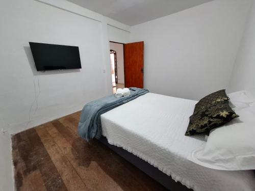 una camera da letto con un letto e una tv a parete di AP 01 Itacolomy com piscina aquecimento solar a Ouro Preto