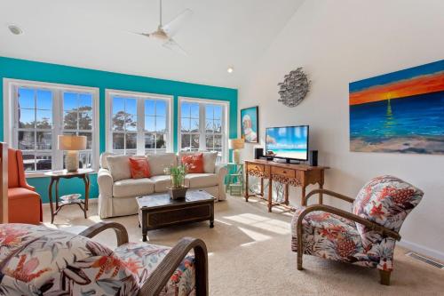 Una sala de estar con un sofá y un televisor. en 5530 - The Bright Side, en Kill Devil Hills