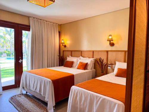a hotel room with two beds and a window at Terrasa Solar Hotel in Icaraí