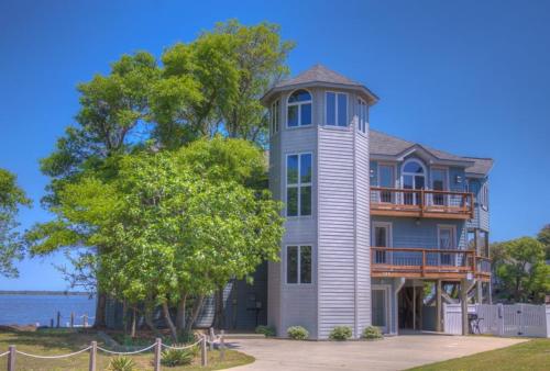 a large house with a balcony on top of it at 5550 - Lighthouse Pointe in Kill Devil Hills