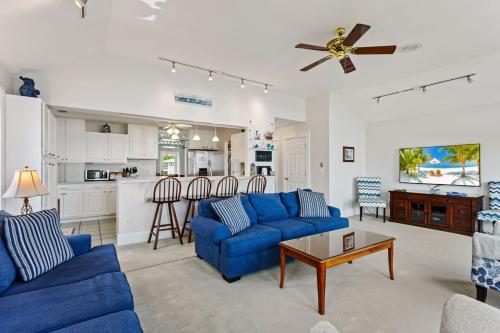 a living room with blue couches and a kitchen at 5550 - Lighthouse Pointe in Kill Devil Hills