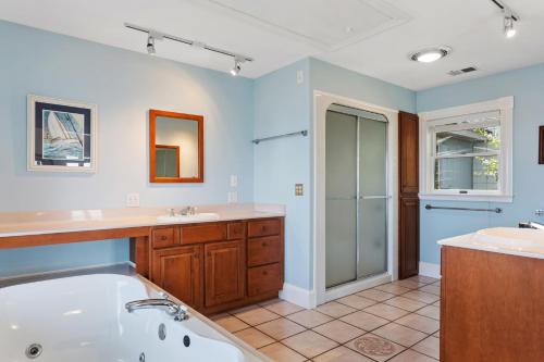 a bathroom with a tub and a sink at 5550 - Lighthouse Pointe in Kill Devil Hills