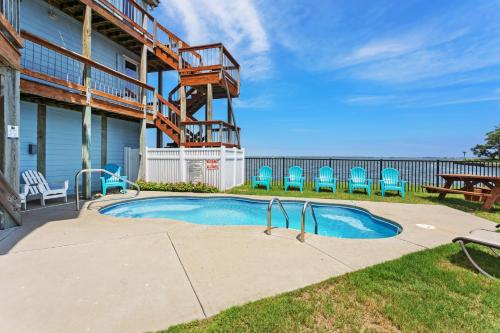 a small swimming pool with chairs and a deck at 5550 - Lighthouse Pointe in Kill Devil Hills