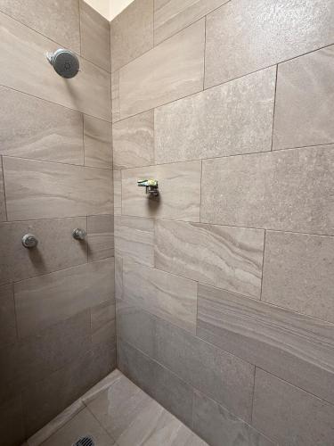 a bathroom with a shower with a stone wall at Casa del Lago in Veracruz