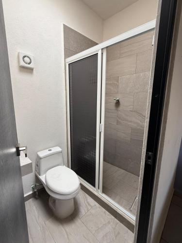 a bathroom with a toilet and a walk in shower at Casa del Lago in Veracruz