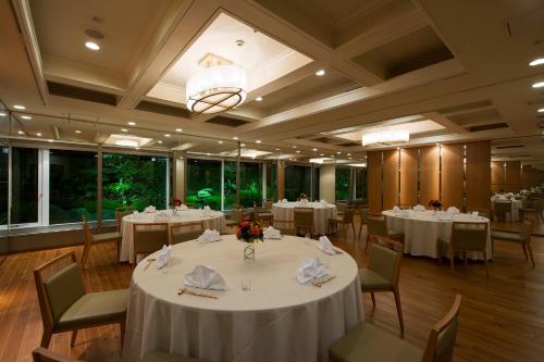 a banquet hall with white tables and chairs at ANA Crowne Plaza Hiroshima by IHG in Hiroshima