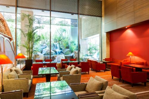 a lobby with chairs and tables and a large window at ANA Crowne Plaza Hiroshima by IHG in Hiroshima