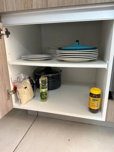 a white cabinet with plates and dishes in it at Casa del Lago in Veracruz
