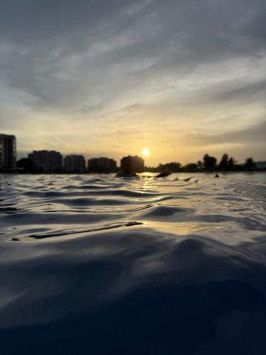 a sunset on a snowy beach with a city in the background at Casa del Lago in Veracruz
