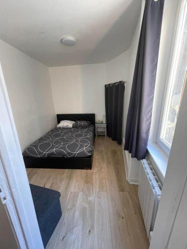 Appartement type 2 في Beaumont: غرفة نوم مع سرير وأرضية خشبية