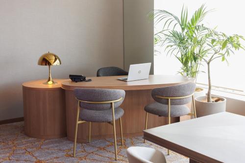 an office with a desk with chairs and a laptop at ANA Crowne Plaza Hiroshima by IHG in Hiroshima