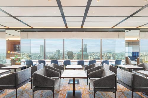 a restaurant with tables and chairs and a view of the city at ANA Crowne Plaza Hiroshima by IHG in Hiroshima