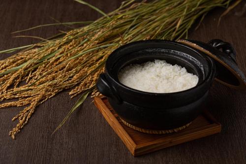 a black pot of rice on a board next to a bunch of wheat at ANA Crowne Plaza Hiroshima by IHG in Hiroshima