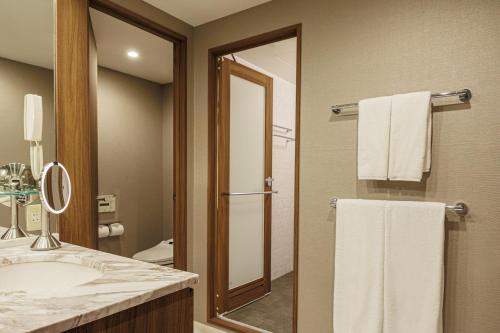 a bathroom with a sink and a mirror and towels at ANA Crowne Plaza Hiroshima by IHG in Hiroshima