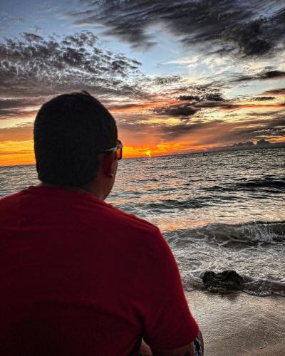 a man sitting on the beach watching the sunset at Brisas del Mar vista al Mar in Playa Blanca