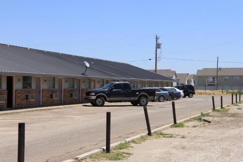 a black truck parked on the side of a road at Lodge USA Motel in Guymon