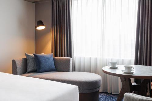 a hotel room with a bed and a chair and a table at ANA Crowne Plaza Hiroshima by IHG in Hiroshima