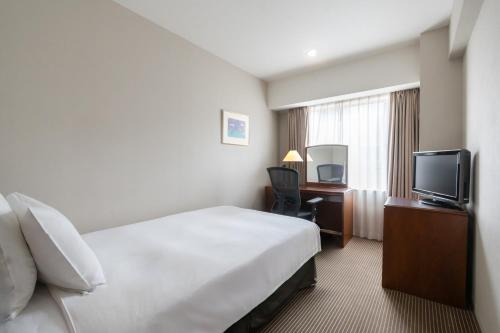 a hotel room with a bed and a television at ANA Crowne Plaza Hiroshima by IHG in Hiroshima