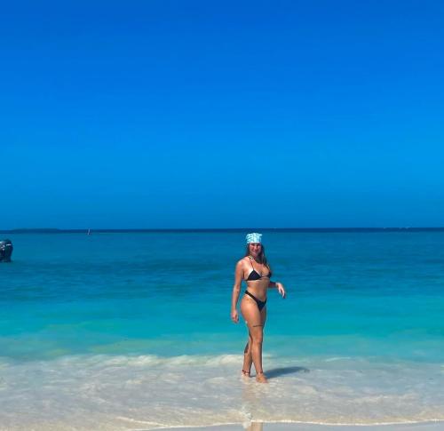 a woman standing in the water on the beach at Brisas del Mar vista al Mar in Playa Blanca