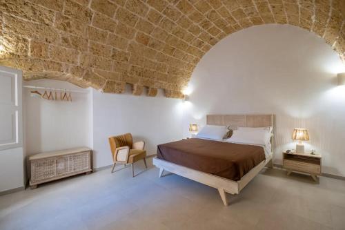 a bedroom with a bed and a brick wall at Le Antiche Dimore in Montesano Salentino
