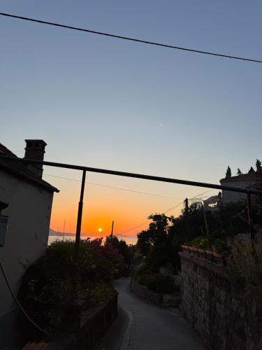 an empty street with a sunset in the background at Stylish Stone House for Two in Koločep