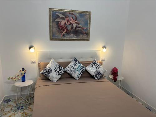 a room with a bed with pillows and a painting on the wall at Vendicari in Pachino