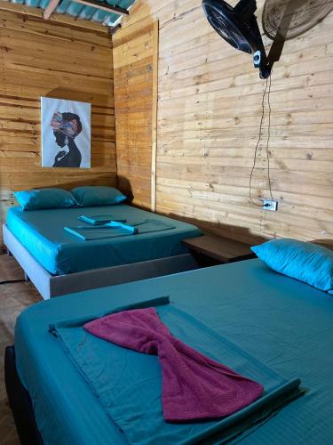 two beds in a room with wooden walls at Brisas del Mar vista al Mar in Playa Blanca