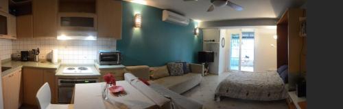 a kitchen and a living room with a couch and a table at Cozy Beachfront Studio in San Juan