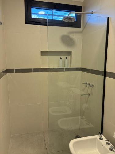 a glass shower in a bathroom with a sink at Departamento macrocentro II, espacioso Río Cuarto in Río Cuarto