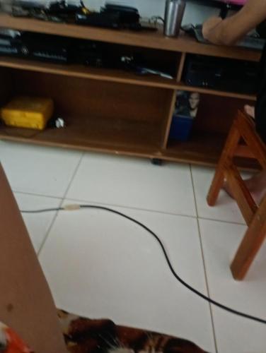 una stanza con un tavolo con una tv e un cavo sul pavimento di Sooll a Salvador