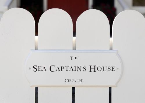 a sign for the sea captains house on a white fence at The Sea Captains House by Paradise Retreats in Santa Barbara