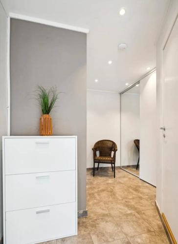a room with a white dresser and a chair at Apartment in Narvik