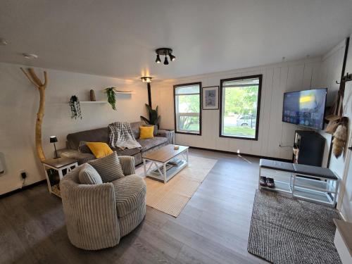 a living room with a couch and a tv at The Hilltop in Whitehorse