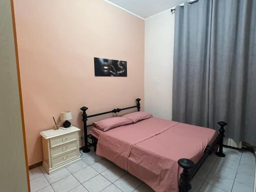 a bedroom with a bed with a pink bedspread at Apartment in Alexandria! in Alessandria