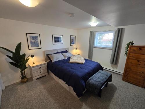 a bedroom with a bed and a dresser and a window at The Hilltop in Whitehorse